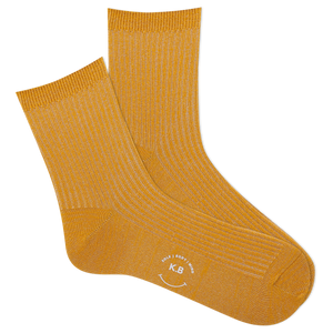 Pair of metallic gold socks with a K.Bell logo on a white background