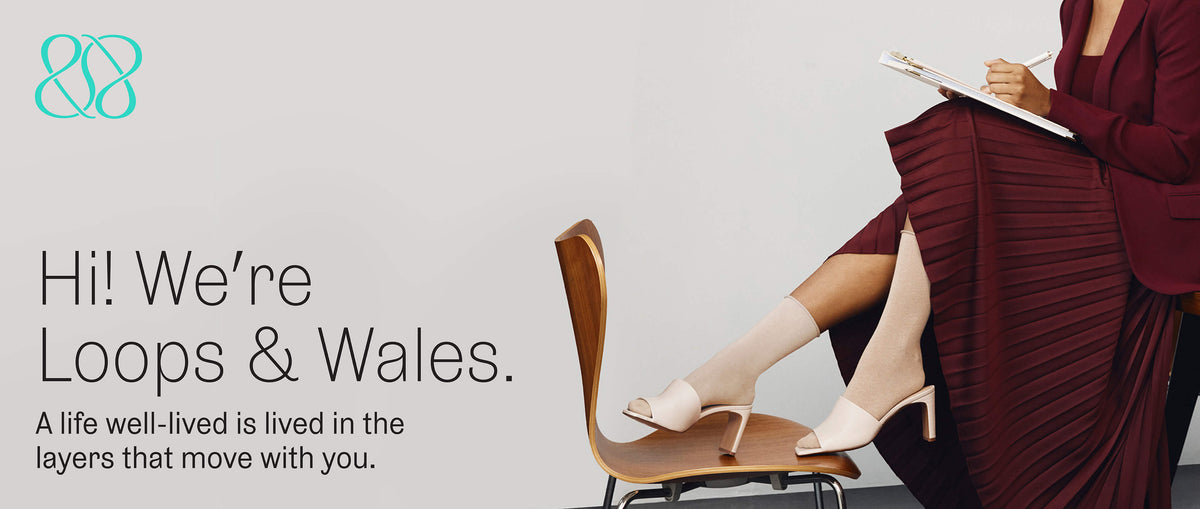 Loops and Wales hero with the text "Hi! We're Loops & Wales. We believe a life well-lived is in the layers that move with you everyday and a closeup of a woman in a professional burgundy outfit and K.Bell beige roll top socks.