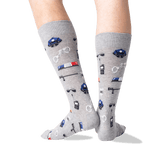 A pair of heather gray crew socks with a police-themed print, worn on a person's legs against a plain white background.