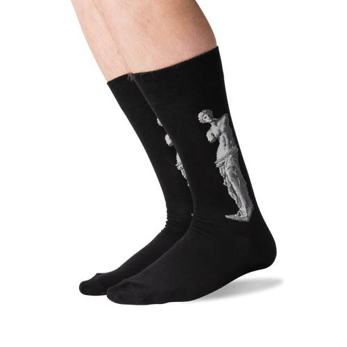 Black crew socks worn on a person's legs, featuring a light gray classical statue graphic printed on the side.