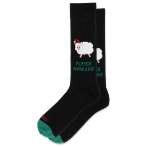 A pair of black crew socks with a festive Christmas design. The front sock features a white fluffy sheep wearing a red Santa hat above the green text 'FLEECE NAVIDAD MATA'.