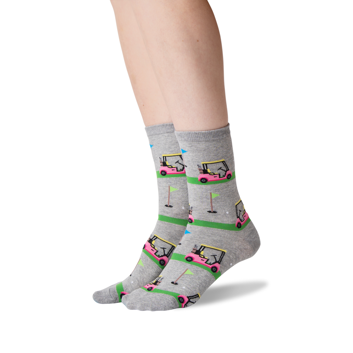 A pair of gray crew socks with a colorful golf course and golf cart pattern, worn on a person's feet against a white background.