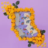 Pair of socks with elephant design surrounded by yellow flowers on a purple background