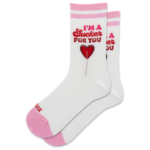 A pair of white crew socks with pink stripes at the top and pink toes/heels, featuring a red graphic of a lollipop and the text 'I'M A Sucker FOR YOU' on the front.