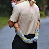 Child wearing socks with emoji patterns, embracing his father outdoors. thumbnail