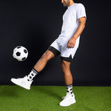 Person in white sports outfit kicking a soccer ball on a green field with black background thumbnail