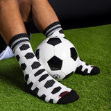 Person wearing black and white patterned socks with a soccer ball on grass