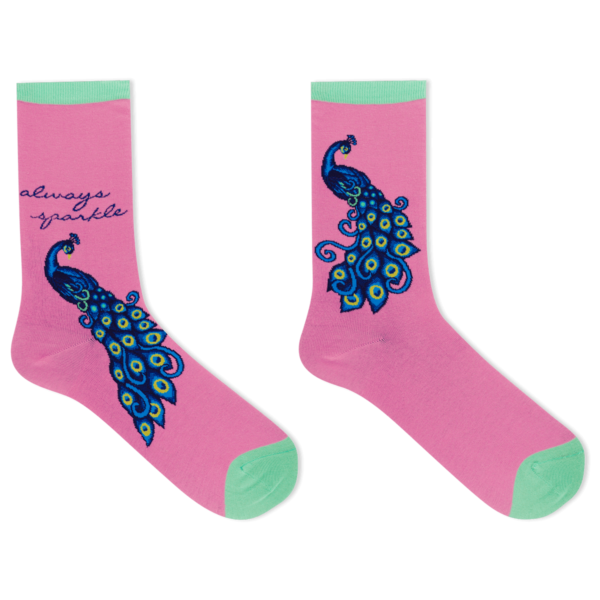 A pair of pink crew socks with mint green toes and heels, featuring a large blue and green peacock design and the text 'always sparkle' on one sock, shown on a white background.