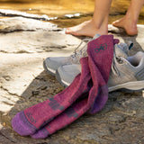 Purple hiking socks with a logo on gray shoes by a stream thumbnail
