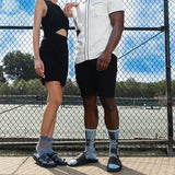 Two people standing on a tennis court wearing socks with blue and black patterns. thumbnail