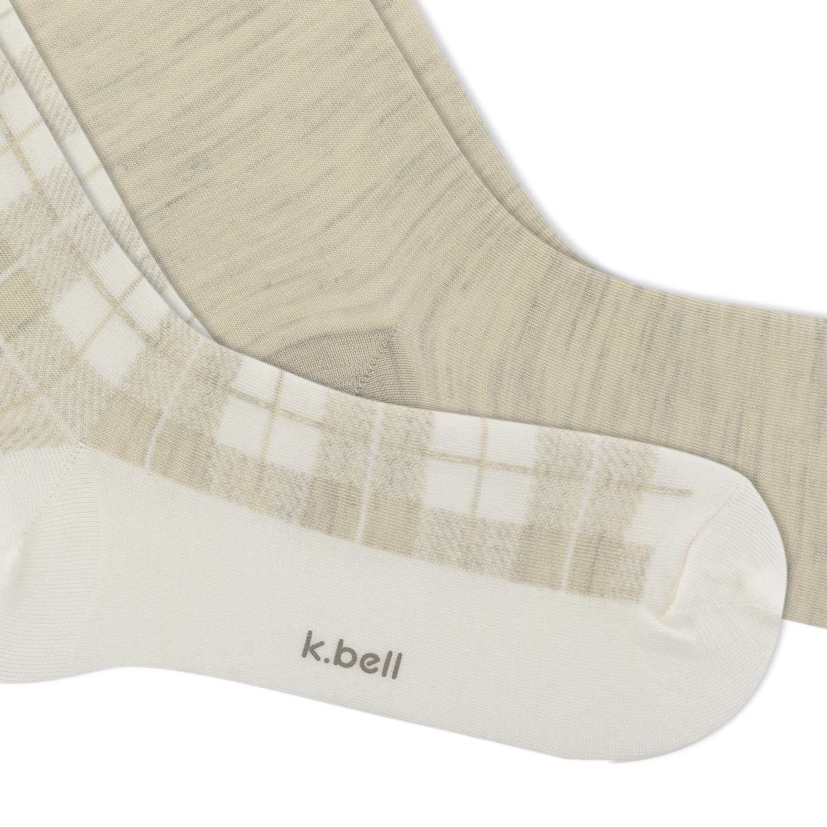 A close-up of a pair of K.Bell socks in a soft beige and white colorway.