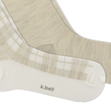 A close-up of a pair of K.Bell socks in a soft beige and white colorway. thumbnail
