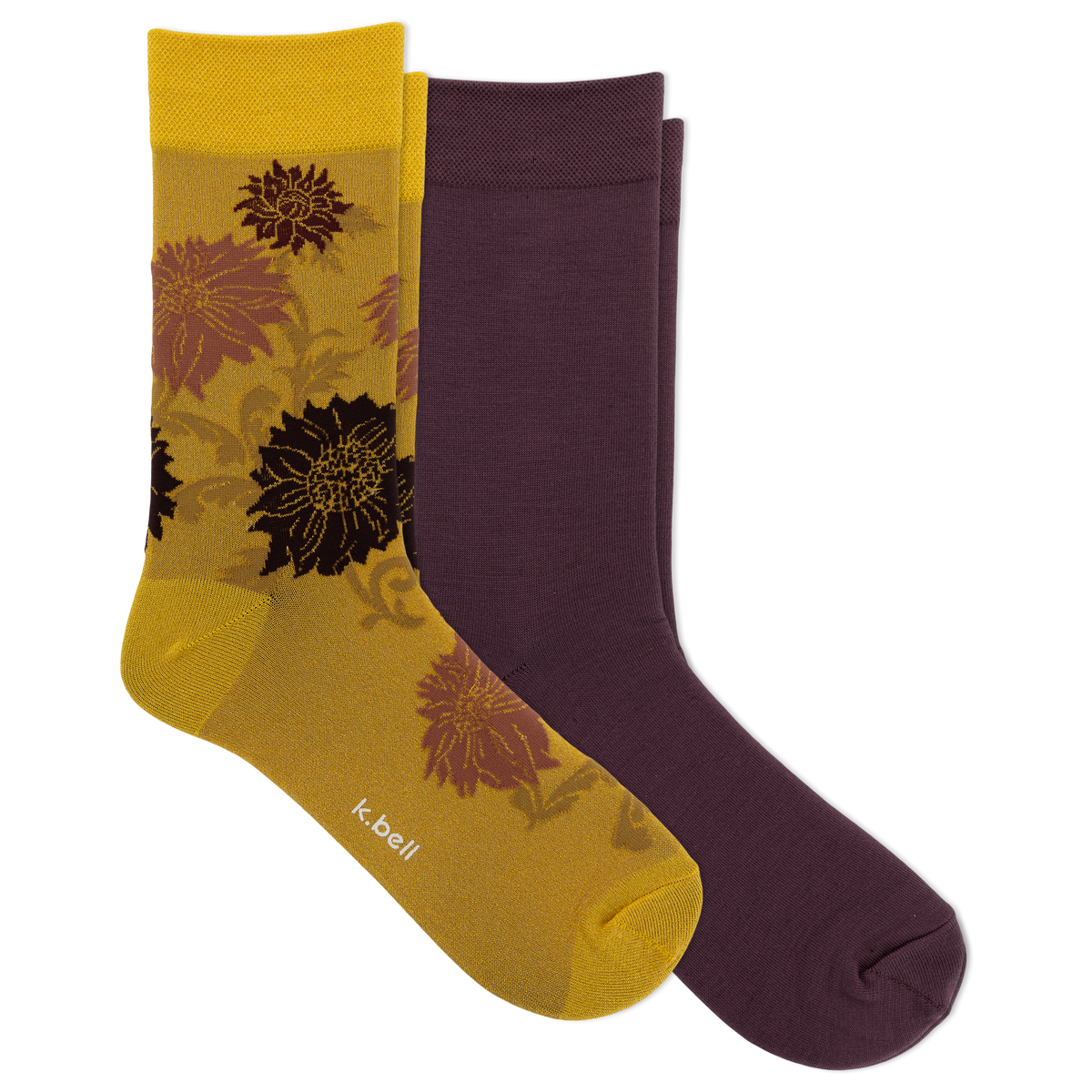 Two pairs of crew socks from K-Bell: one pair is solid dark plum purple, and the other pair is metallic gold with a floral pattern in brown and black. The yellow pair has the K-Bell brand name printed near the toe.