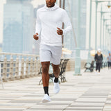 Man running on a city street wearing a white outfit