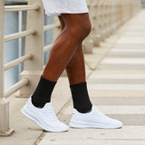 Person wearing white sneakers and black socks on a stone staircase. thumbnail
