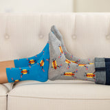 Two pairs of socks, one blue and one gray, with hot dog pattern on a light-colored couch. thumbnail