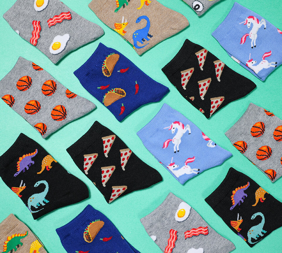 Collection of colorful kids' novelty socks with various patterns on a teal background