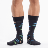 Black socks with colorful fish pattern worn by a person on a white background thumbnail