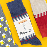 THhree pairs of socks with different alcohol designs on a yellow background