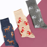 Three pairs of socks with animal patterns on a geometric background