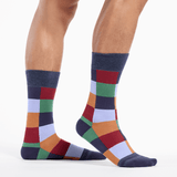 Colorful checkered socks worn by a person on a white background