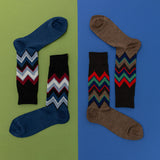 Two pairs of socks with zigzag chevron patterns on a green and blue background thumbnail