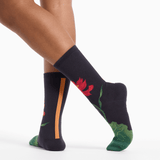 Black socks with floral designs worn by a person on a white background thumbnail