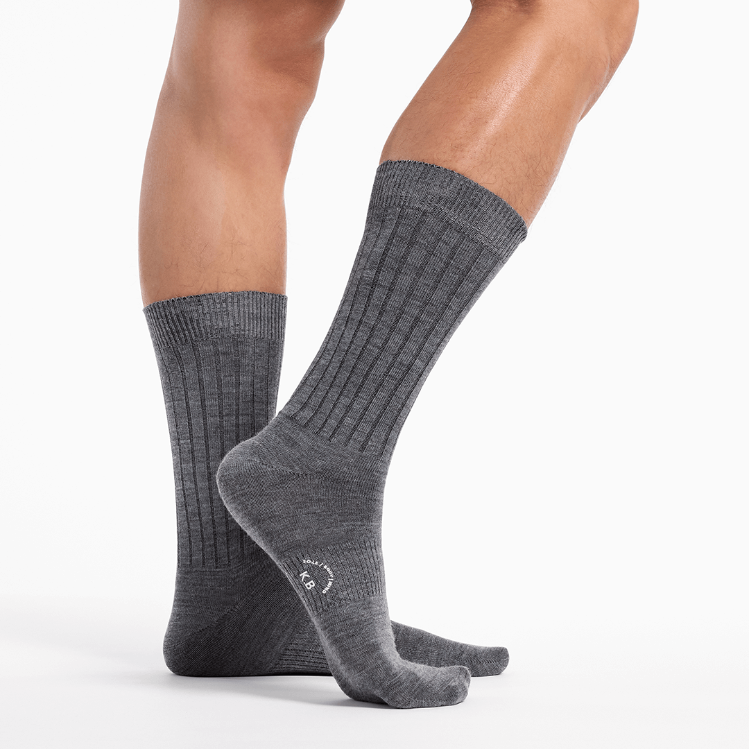 Gray socks worn by a person on a white background