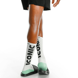 White socks with 'Iconic' text and green accents worn by a person on a white background