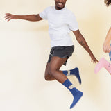 Person wearing blue socks with a design that says "Sun day Fun day" on a beige background thumbnail