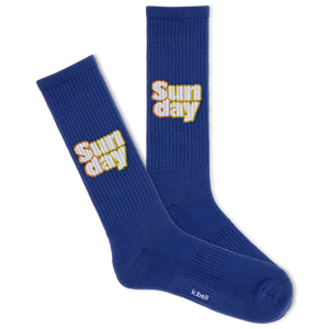 A pair of blue crew socks with the text 'SUNDAY' and a bell logo on the side.