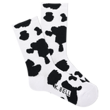 A pair of white crew socks with black cow print and the brand name 'K.BELL' written across the foot. thumbnail
