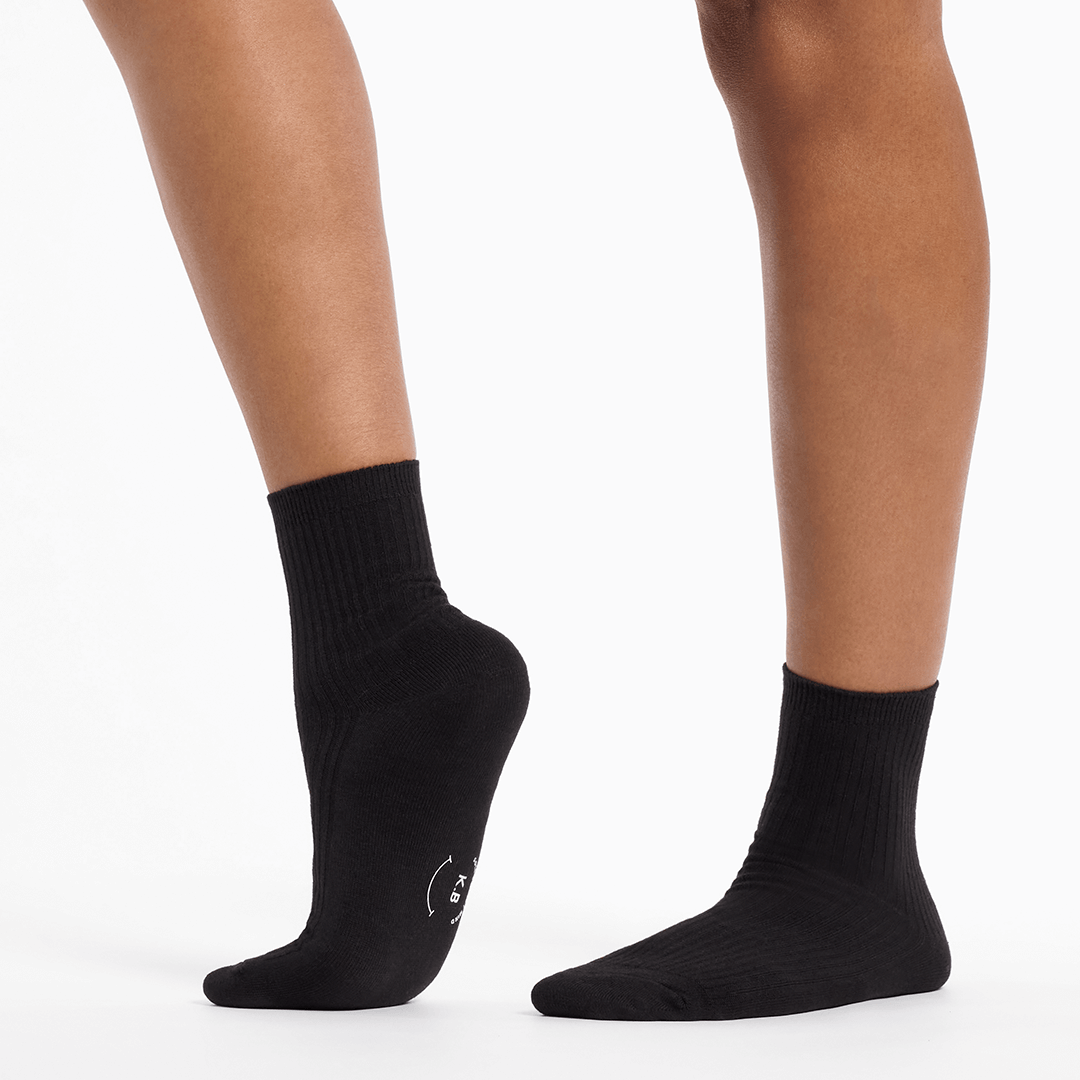 Black socks worn by a person on a white background
