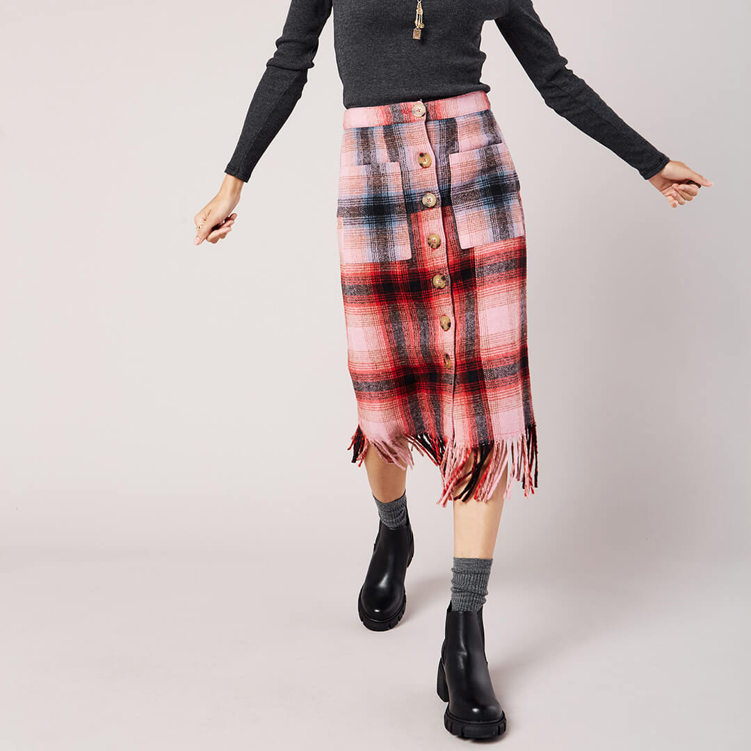 Person wearing a plaid skirt with a plain background