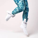 Blue tie-dye leggings worn by a person on a light pink background