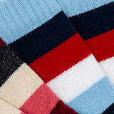 Close-up of multicolored socks with red, blue, black, and beige stripes. thumbnail