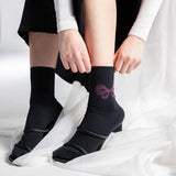 Person wearing black socks with a Black socks with a rhinestone bow design and 'k.bell' branding on a white background thumbnail