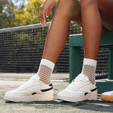 Person wearing white sneakers with black accents and crochet net crew socks outdoors. thumbnail