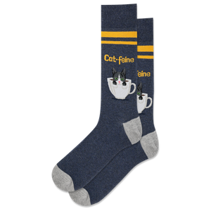 A pair of navy crew socks with a pattern of white cat faces and coffee cups, and yellow stripes.